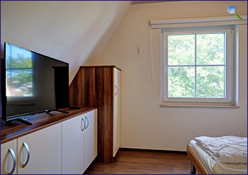 Ein Schlafzimmer im Dachgeschoss mit TV
